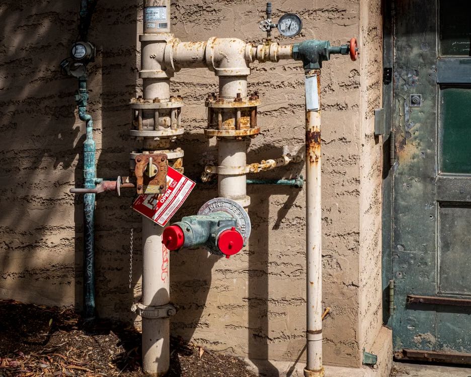 Commercial building fire department connection and backflow piping with valves and pressure gauge